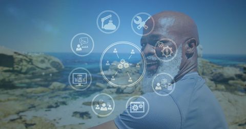 Smiling Senior African American Man on Beach with Digital Technology Icons