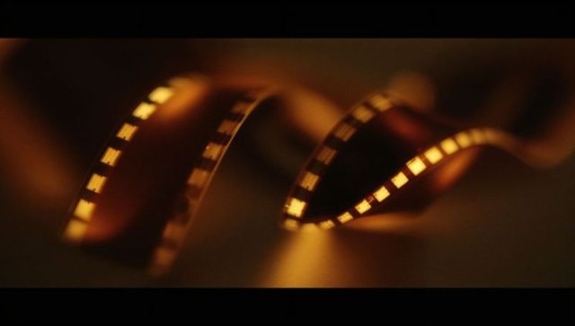 Cinematic 35mm film strip with sprocket holes on tabletop