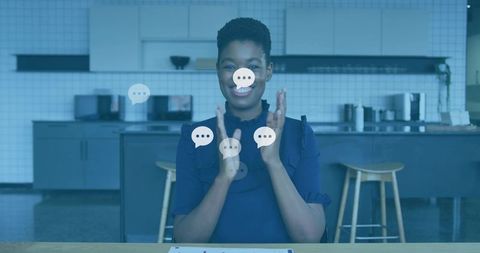 Clapping host celebrating virtual feedback with chat bubbles in modern kitchen