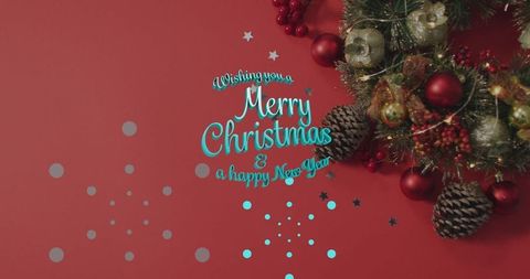 Festive Wreath and Greeting on Red Christmas Background with Confetti
