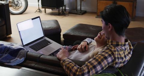 Couple in Relaxed Home Setting Cozying Up with Laptop