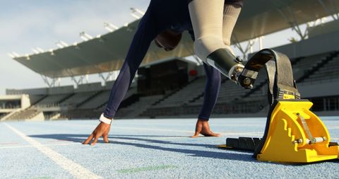 Paralympic Athlete in Dynamic Start Position on Track