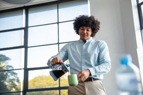 Professional man pouring coffee in office break room