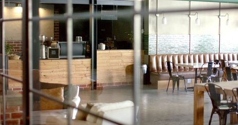 Light wooden coffee counter with espresso machine and industrial lounge seating