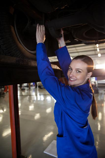 Portrait of female mechanic servicing car at the repair garage