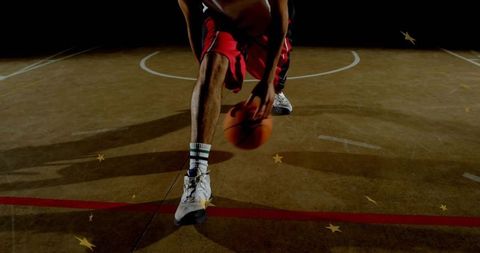 Basketball Player Dribbling on Court Under Spotlight