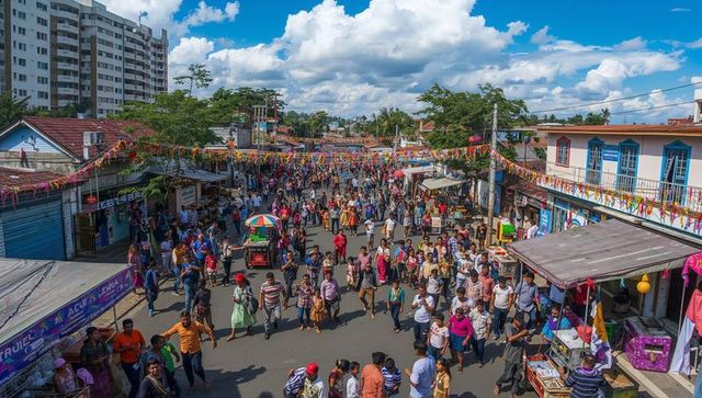 Colorful street festival crowd celebrating with market vendors and pennant banners