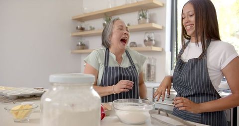 Asian Grandmother and Granddaughter Bonding over Baking in Kitchen