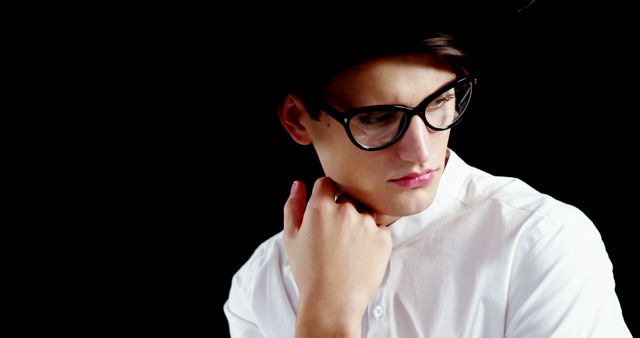 Stylish Young Man in Glasses and White Shirt Looking Away Thoughtfully - Download Free Stock Images Pikwizard.com