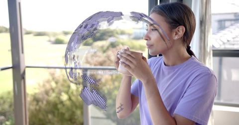 Woman sipping coffee on balcony with holographic globe augmented reality, contemplative
