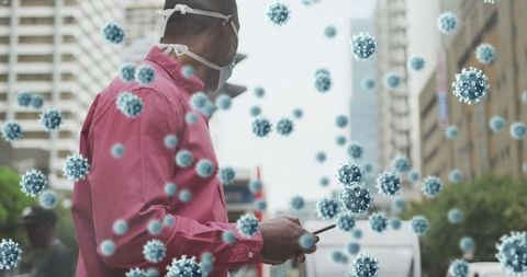 Man wearing face mask navigating smartphone amid covid-19 cells