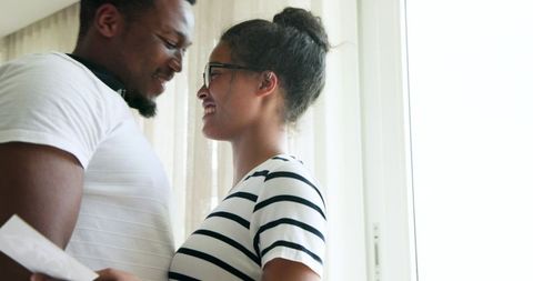 Happy couple sharing exciting pregnancy moment at home