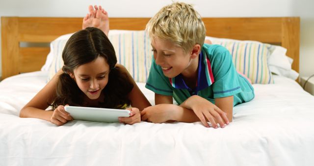 Children Lying on Bed Watching Tablet and Smiling - Download Free Stock Images Pikwizard.com