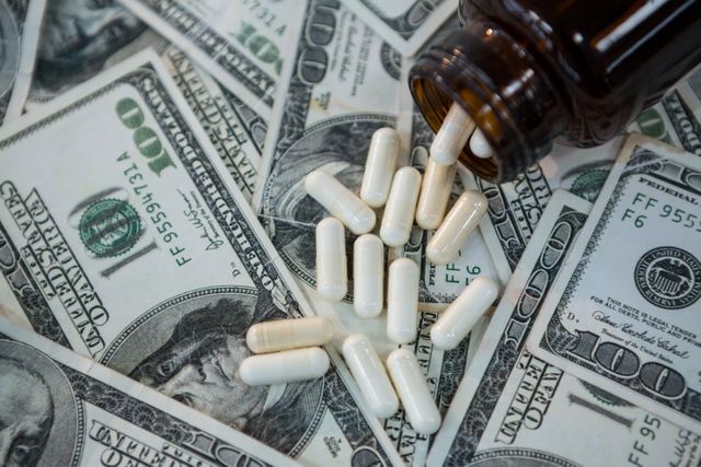 Pills Spilling on US Dollar Bills - Download Free Stock Photos Pikwizard.com
