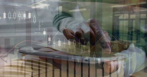 Mid-adult man touching tablet analyzing candlestick and line charts financial dashboard