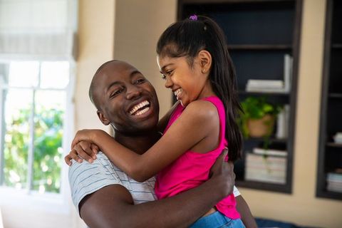 Cheerful Father Embracing Daughter in Cozy Home Environment