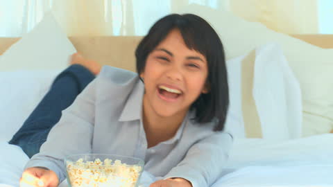 Joyful Woman Relaxing While Watching TV at Home