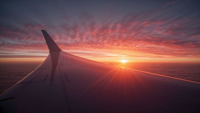 Sunset View Above Clouds from Airplane Window