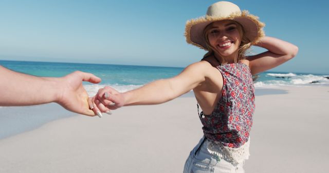 Happy caucasian woman holding man's hand by seaside with copy space. Lifestyle, vacation, summer, happiness, wellbeing concept, unaltered.
