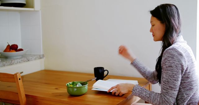 Woman enjoying healthy meal while reading a book at home - Download Free Stock Images Pikwizard.com