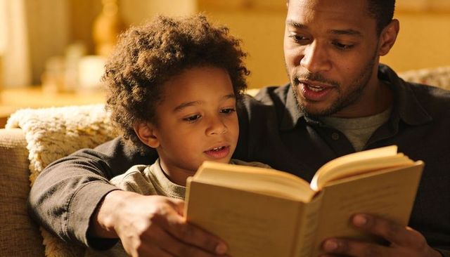 Evening storytime father reading bedtime book with child on cozy sofa