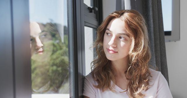 Thoughtful Young Woman Looking Through Window with Reflection - Download Free Stock Images Pikwizard.com