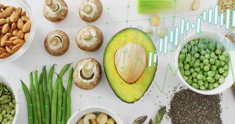 Halved avocado surrounded by green vegetables nuts and seeds with nutrition data overlay