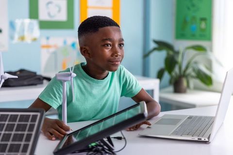 African american boy exploring renewable energy with wind turbine and solar panel