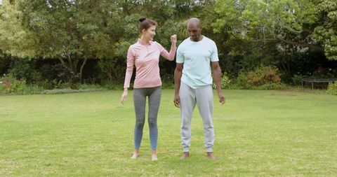 Diverse Friends Practicing Outdoor Stretches on Garden Lawn for Wellness