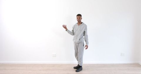 African American Man in Gray Tracksuit Performing Mime Against White Background - Download Free Stock Images Pikwizard.com