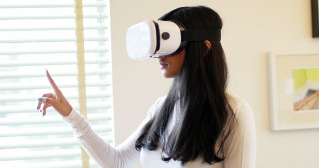 Woman using virtual reality headset in living room at home