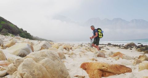Senior man hiking beachfront adventure with backpack