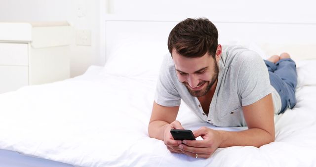 Man Lying on Bed Using Smartphone and Smiling - Download Free Stock Images Pikwizard.com