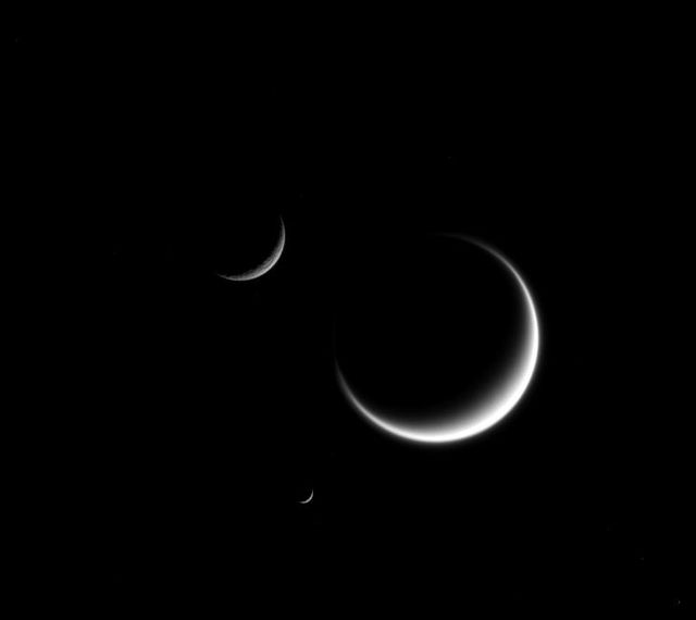 A single crescent moon is a familiar sight in Earth's sky, but with Saturn's many moons, you can see three or even more.  The three moons shown here -- Titan (3,200 miles or 5,150 kilometers across), Mimas (246 miles or 396 kilometers across), and Rhea (949 miles or 1,527 kilometers across) -- show marked contrasts. Titan, the largest moon in this image, appears fuzzy because we only see its cloud layers. And because Titan's atmosphere refracts light around the moon, its crescent "wraps" just a little further around the moon than it would on an airless body. Rhea (upper left) appears rough because its icy surface is heavily cratered. And a close inspection of Mimas (center bottom), though difficult to see at this scale, shows surface irregularities due to its own violent history.  This view looks toward the anti-Saturn hemisphere of Titan. North on Titan is to the right. The image was taken in visible light with the Cassini spacecraft narrow-angle camera on March 25, 2015.  The view was obtained at a distance of approximately 2.7 million miles (4.3 million kilometers) from Titan. Image scale at Titan is 16 miles (26 kilometers) per pixel. Mimas was 1.9 million miles (3.0 million kilometers) away with an image scale of 11 miles (18 kilometers) per pixel. Rhea was 1.6 million miles (2.6 million kilometers) away with an image scale of 9.8 miles (15.7 kilometer) per pixel.  http://photojournal.jpl.nasa.gov/catalog/pia18322