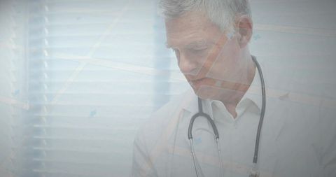 Senior doctor reviewing patient chart by window with stethoscope, clinical care concept