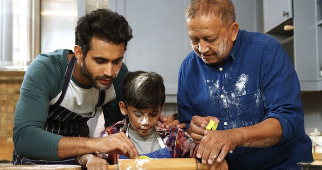 An elderly man, a middle-aged man, and a young boy are baking together in the kitchen. They are working with rolling pins and dough, with flour on their faces. This scene exemplifies family bonding, tradition, and the teaching of culinary skills. Ideal for promoting family values, culinary education, and multicultural moments.