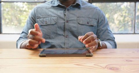 Man Using Tablet at Wooden Desk in Modern Office - Download Free Stock Images Pikwizard.com