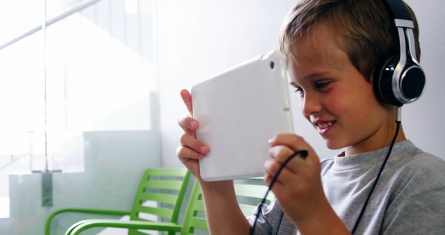 Happy Child Using Tablet with Headphones for Online Learning - Download Free Stock Images Pikwizard.com