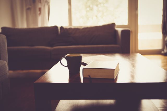 Cozy Living Room with Sofa, Coffee Cup and Book on Wooden Table - Download Free Stock Photos Pikwizard.com