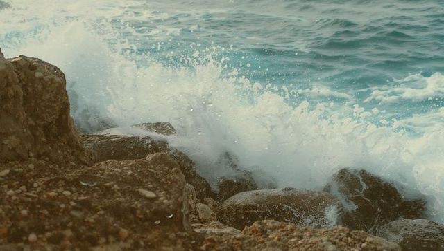 Crashing Waves on Rocky Shoreline with Frothy Spray