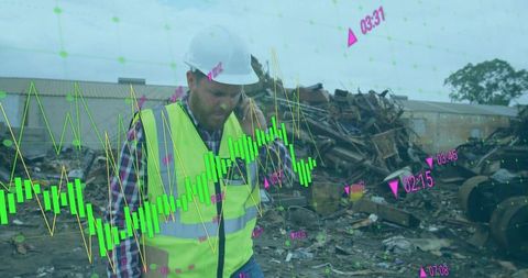 Scrapyard manager monitoring live analytics while inspecting scrap yard in hard hat and vest