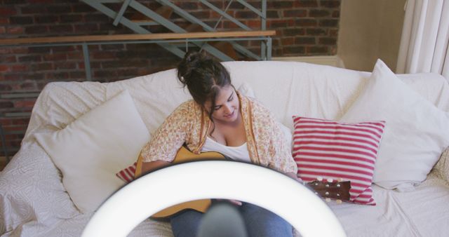 Young woman practicing acoustic guitar in cozy living room - Download Free Stock Images Pikwizard.com