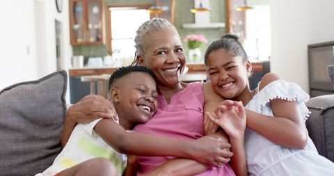 Happy Moments Together: Grandmother and Grandchildren Embracing on Sofa