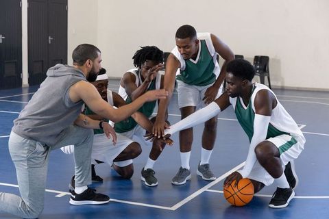 Basketball coach motivating diverse team during huddle