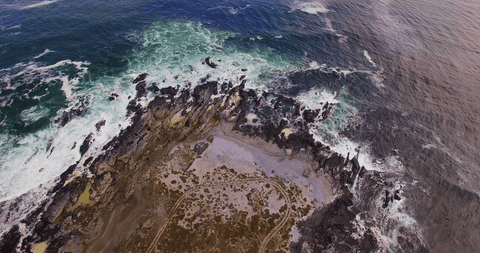 transparent waves crashing on rocky shoreline aerial view - Download Free Stock Videos Pikwizard.com