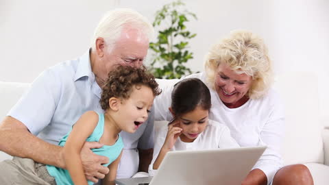 Elderly Couple Engaging with Curious Children on Laptop