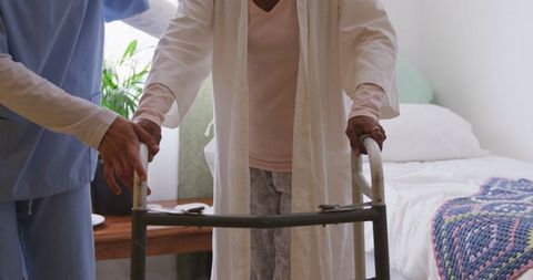 Nurse Assisting Senior African American Woman with Walker