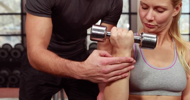 Personal Trainer Guiding Woman Lifting Dumbbell in Gym - Download Free Stock Images Pikwizard.com