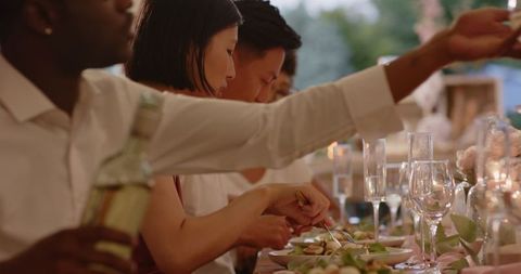 Outdoor Wedding Celebration with Guests Toasting and Enjoying Meal