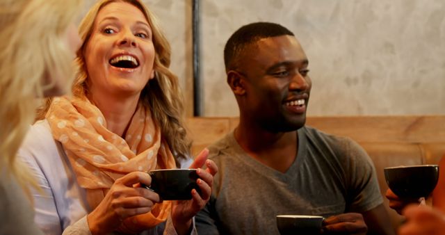 Diverse friends enjoying coffee at café and laughing together - Download Free Stock Images Pikwizard.com